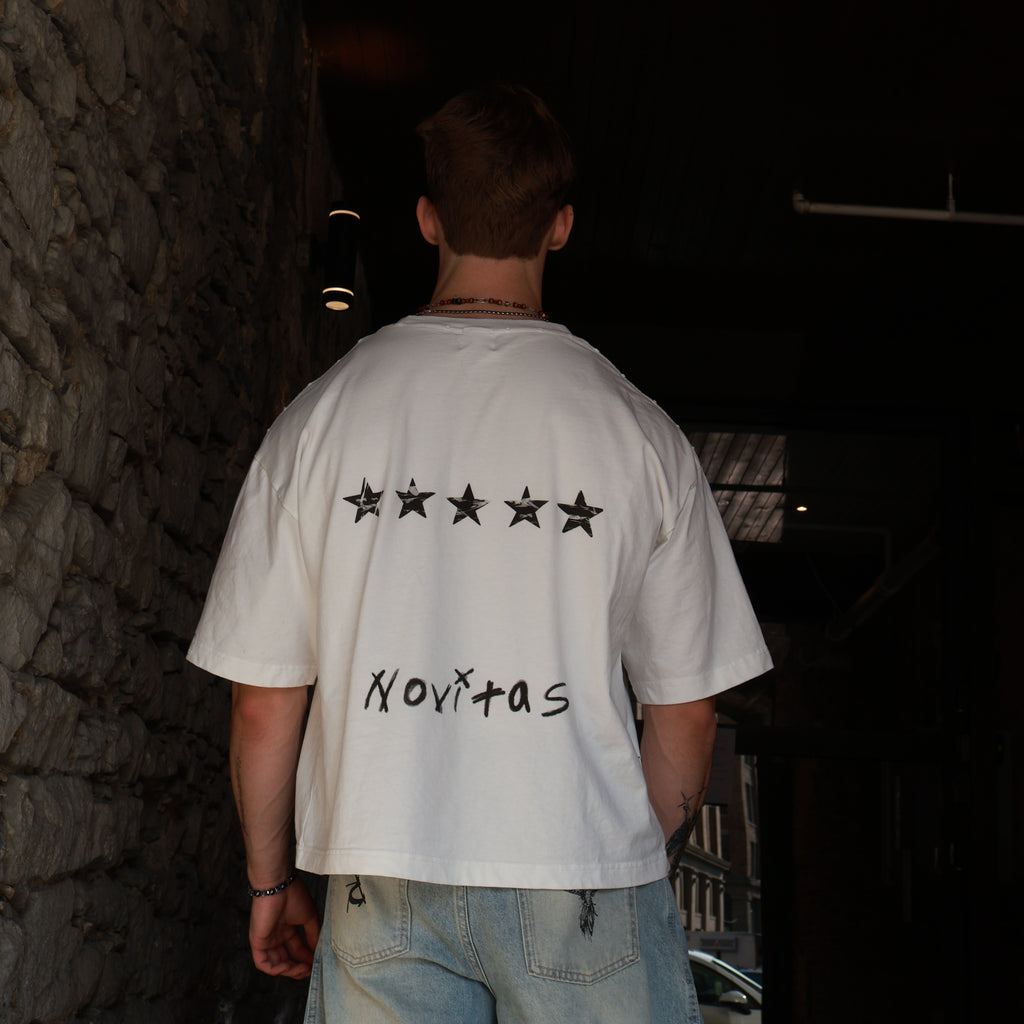 T-shirt N°05 de dos contre un mur de pierre