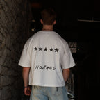 T-shirt N°05 de dos contre un mur de pierre