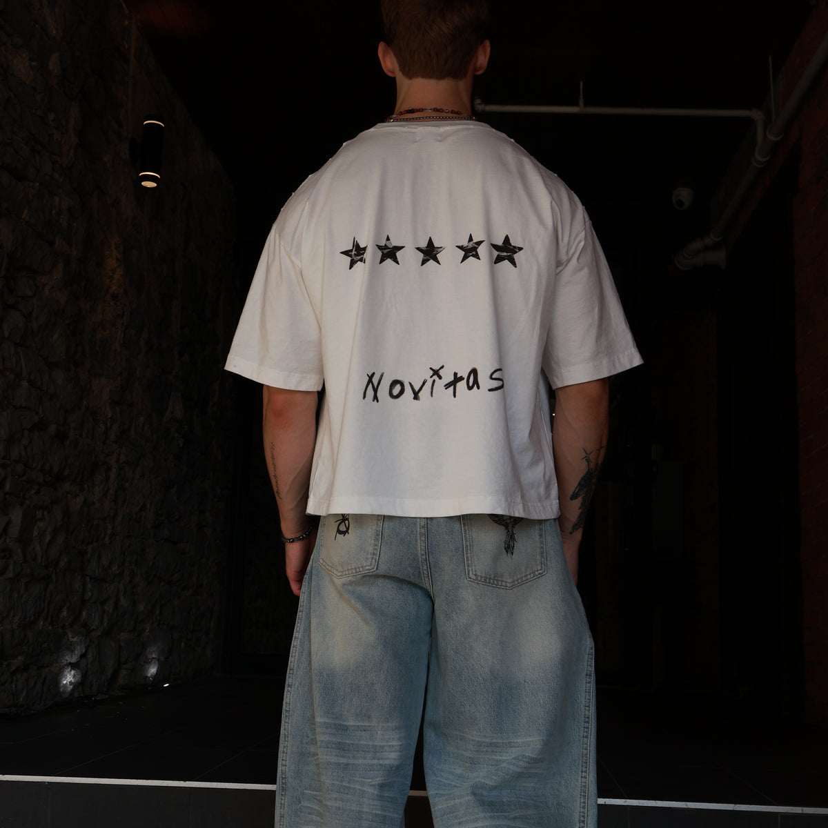 T-shirt N°05 porté de dos, coupe boxy oversized, avec un jean wide leg